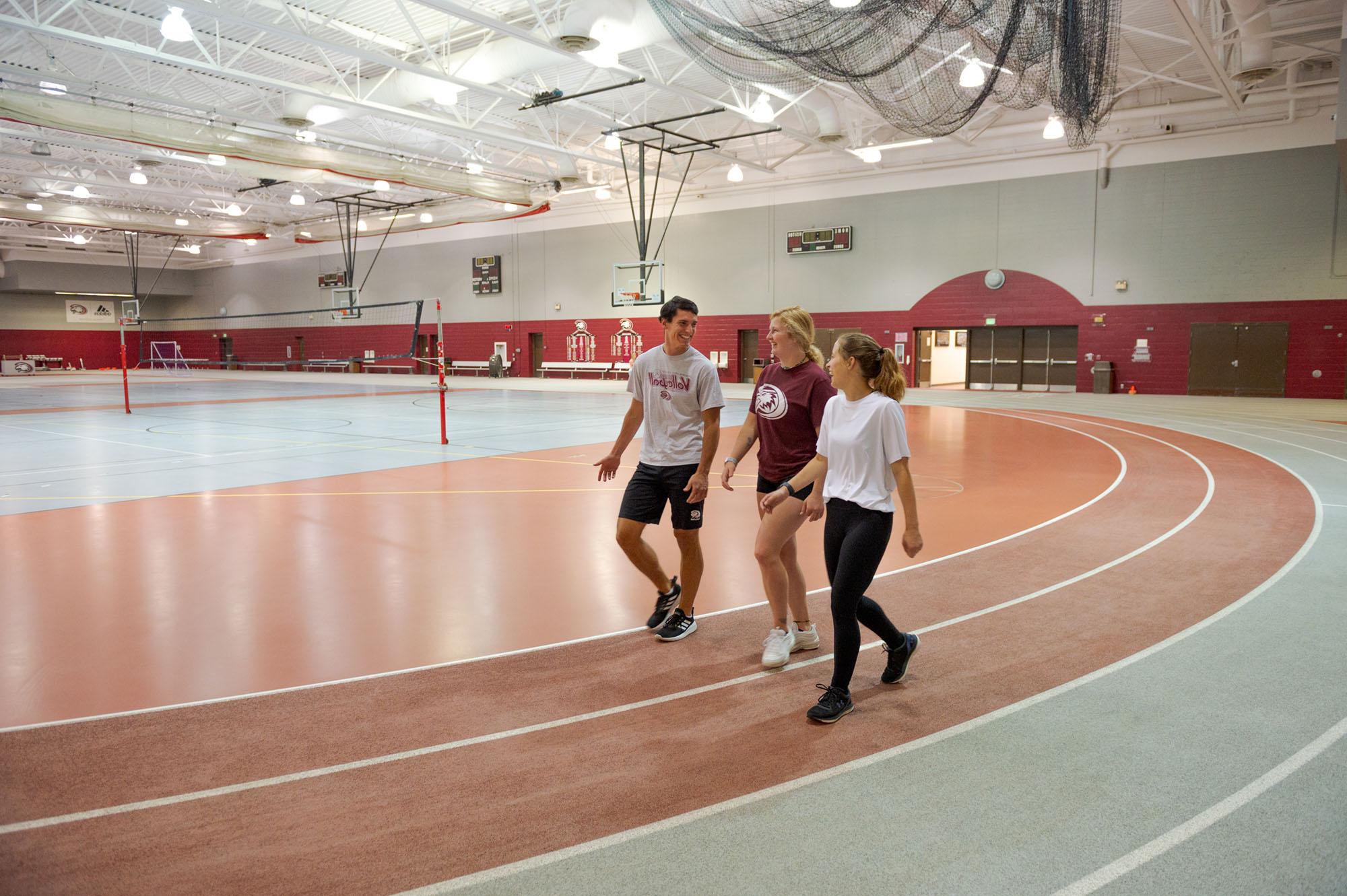 Photo of students walking for exercise around the indoor track at the NPAC