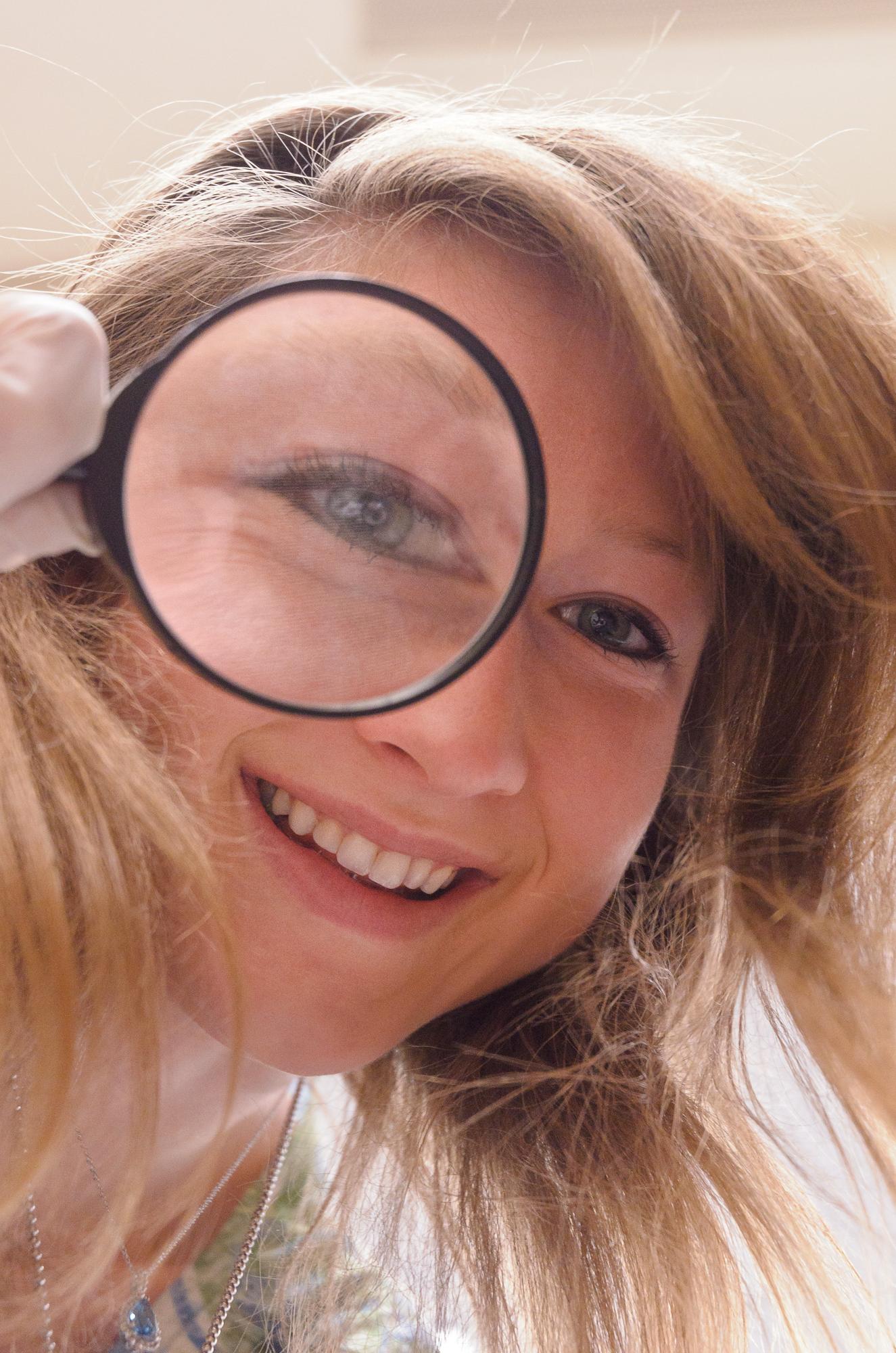 A student looking through a magnifying glass